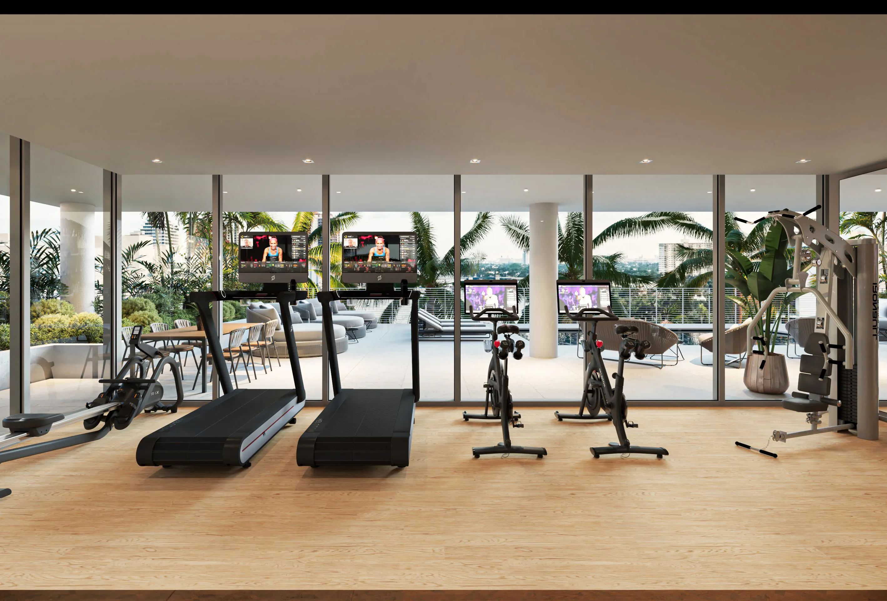 A gym room featuring various exercise equipment and a large window allowing natural light to enter.